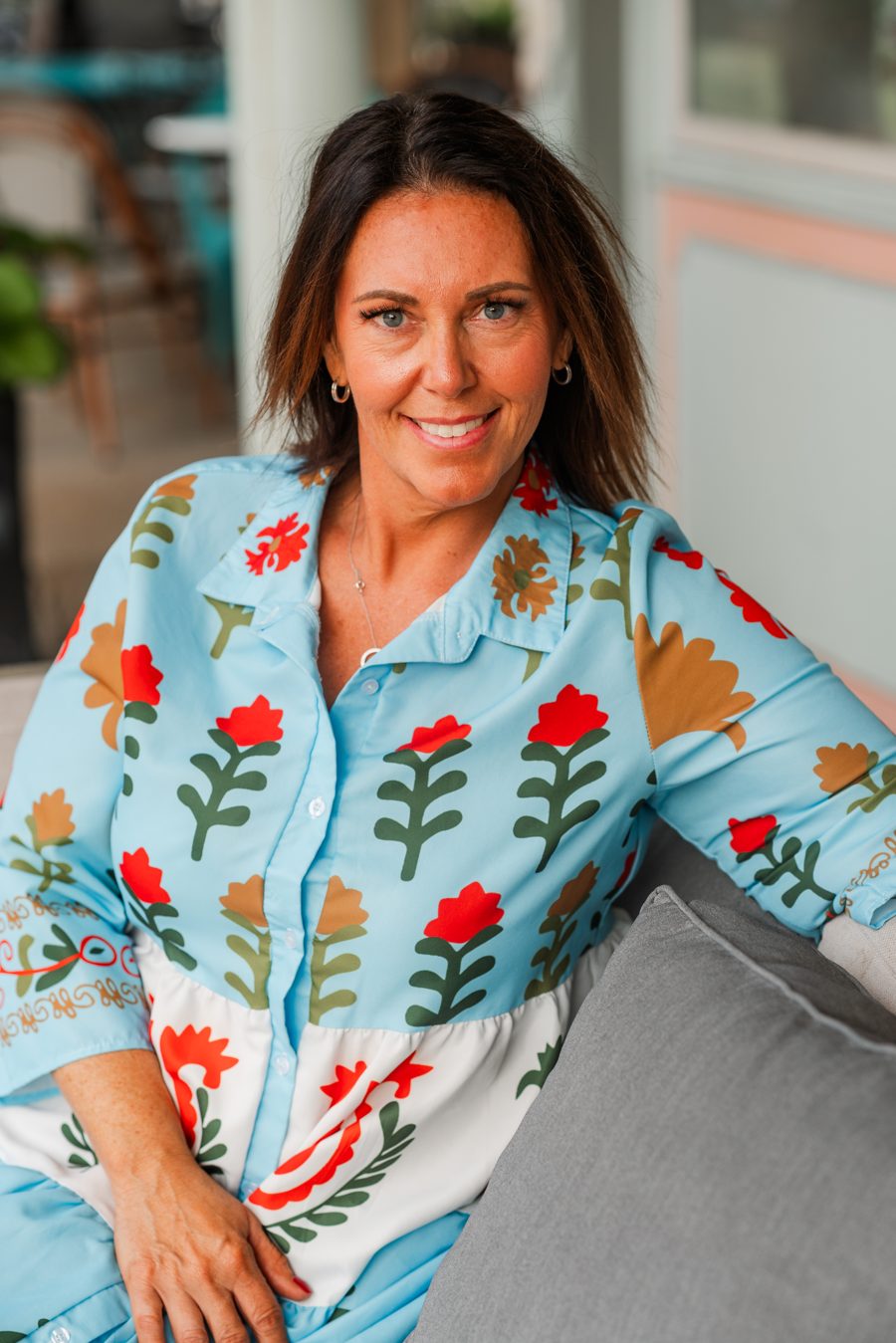 Kelly Harple seated in a blue floral blouse